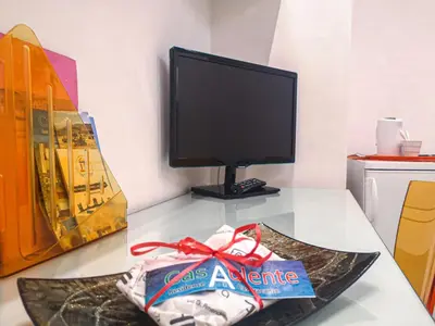 a table with a computer monitor and a bag on it at Casaulente in Alcamo