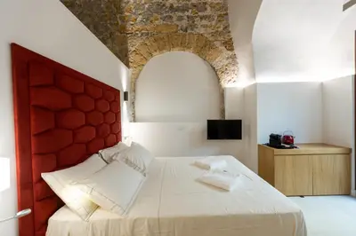 a bedroom with a bed and a glass door at Bastione Spasimo Boutique Hotel in Palermo