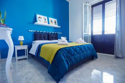 a blue bedroom with a bed with towels on it at Biddizzi Apartment in Palermo