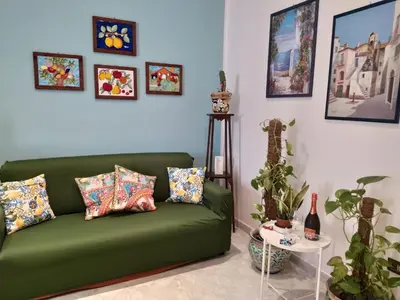 a living room with a green couch and a table at Biddizzi Apartment in Palermo