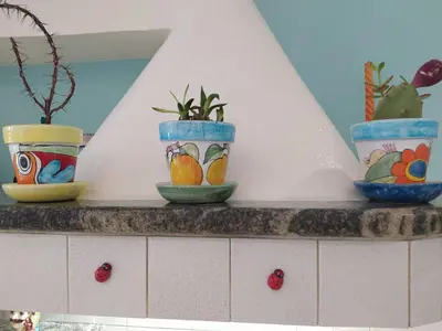 four colorful vases sitting on top of a counter at Biddizzi Apartment in Palermo
