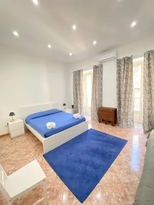 a bedroom with a bed and a blue rug at Marechiaro Apartments in Palermo