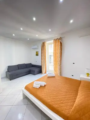 a bedroom with a large bed and a couch at Marechiaro Apartments in Palermo