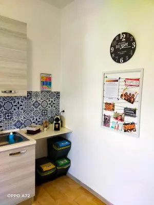 a kitchen with a counter and a clock on the wall at La Coccinella 