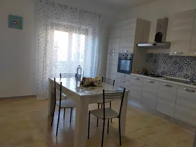 a kitchen with a table and chairs and a window at La Coccinella 