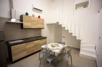 a kitchen with a table and chairs and a staircase at Francesco's Home Palermo in Palermo