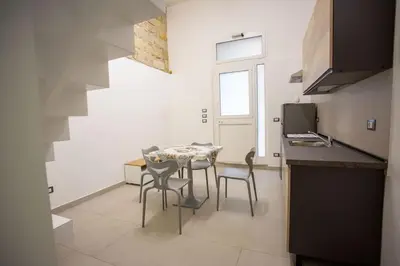a kitchen with a table and chairs in a room at Francesco's Home Palermo in Palermo