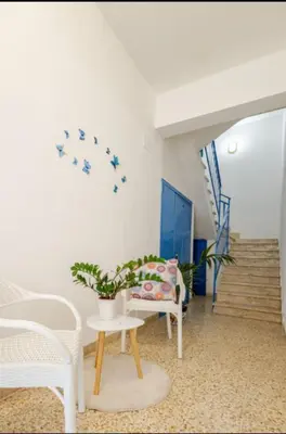 a living room with white chairs and a table with a plant at Spiaggia Libera e di Sabbia dorata per 