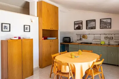 a kitchen with a table and chairs in a room at Villa Piano Vignazza in Scopello