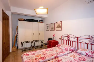 a bedroom with two beds and a cabinet in it at Villa Piano Vignazza in Scopello
