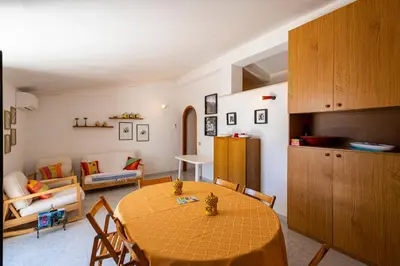 a living room with a table and a couch at Villa Piano Vignazza in Scopello
