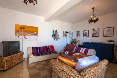 a living room with two couches and a tv at Villa Piano Vignazza in Scopello