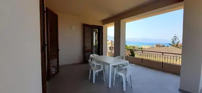 a white table and chairs on a balcony with a view at Casa vacanza Luisa in Alcamo Marina