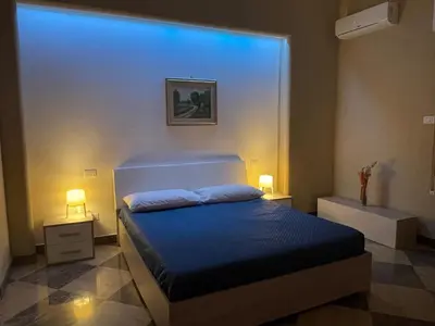 a bedroom with a bed with a large window at Grande Sole Siciliano in Palermo