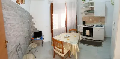 a small kitchen with a table and a sink at Roberto Guest House in Castellammare del Golfo