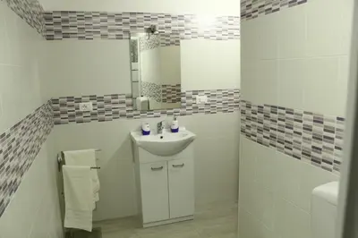 a white bathroom with a sink and a mirror at Roberto Guest House in Castellammare del Golfo