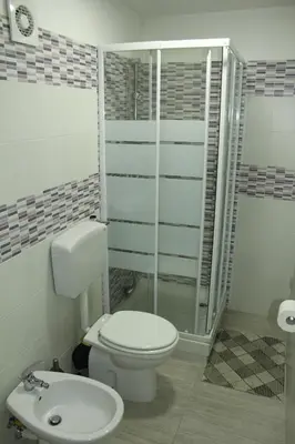 a bathroom with a toilet and a shower and a sink at Roberto Guest House in Castellammare del Golfo