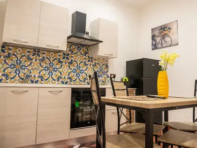 a kitchen and dining room with a table and chairs at Aliva apartment LT in Palermo