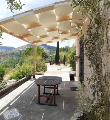 a picnic table under a pergola with a view at La Pedrera Rosa/The Pink Pedrera in Balata di Baida