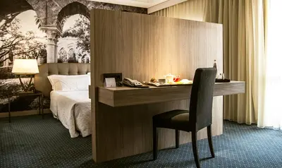a hotel room with a desk and a bed at Hotel Federico II Central Palace in Palermo