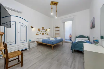 a large bedroom with two beds and a dresser at CoralBay San Vito lo Capo - Appartamento in San Vito lo Capo