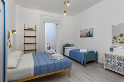 a bedroom with two beds and a book shelf at CoralBay San Vito lo Capo - Appartamento in San Vito lo Capo