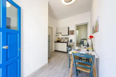 a kitchen and dining room with a blue door at CoralBay San Vito lo Capo - Appartamento in San Vito lo Capo