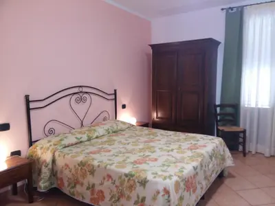 a bedroom with a large bed and a wooden cabinet at Locanda Scirocco in Castellammare del Golfo