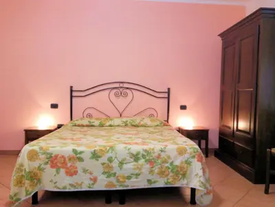 a bedroom with a bed and a pink wall at Locanda Scirocco in Castellammare del Golfo