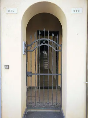 an iron gate in a hallway with an archway at Locanda Scirocco in Castellammare del Golfo