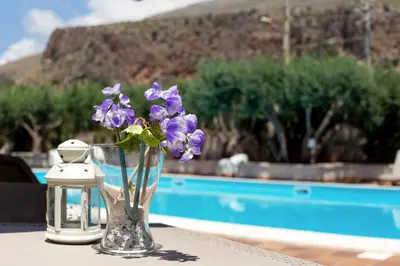 a vase filled with purple flowers sitting on a table at Hotel Achibea in San Vito lo Capo
