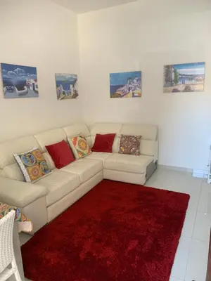 a living room with a white couch and a red rug at Casa Enza Partanna Mondello in Palermo