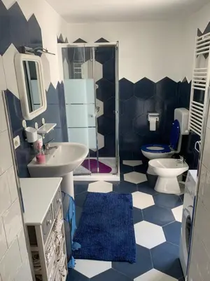 a blue and white bathroom with a toilet and sink at Casa Enza Partanna Mondello in Palermo