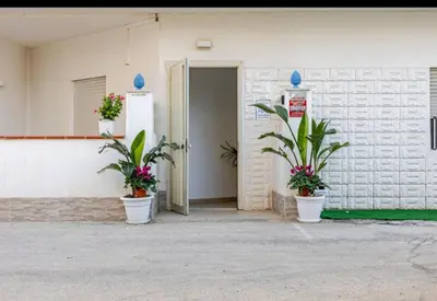 a building with two potted plants in front of a door at Marea il tuo angolo di paradiso in Sicilia ti aspetta prenota ora e vivi la magia del Mediterraneo in Alcamo Marina