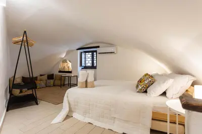 a bedroom with a white bed in a attic at Casa Carolino in Palermo