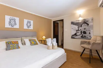 a bedroom with a white bed and a chair at Casa Carolino in Palermo