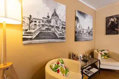 a living room with a chair and a table at Casa Carolino in Palermo