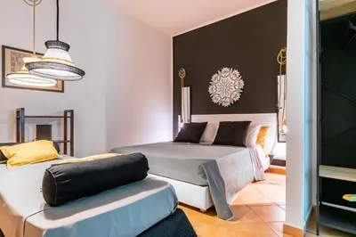 a bedroom with two beds and a couch at GuestHost - Ballarò Central Cozy Studio with Balcony in Palermo