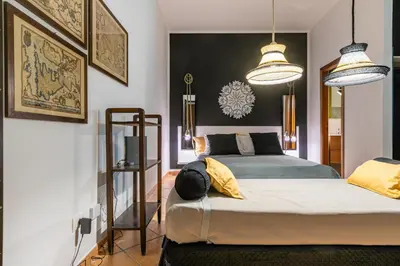 a bedroom with two beds and two pendant lights at GuestHost - Ballarò Central Cozy Studio with Balcony in Palermo