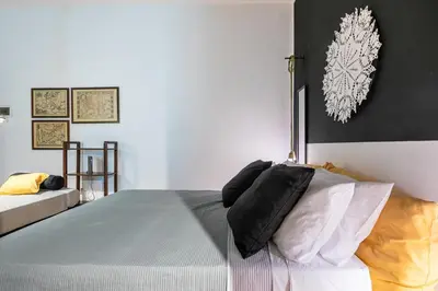 a bedroom with a bed with black and white pillows at GuestHost - Ballarò Central Cozy Studio with Balcony in Palermo
