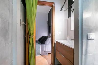 a bathroom with a sink and a door to a bedroom at GuestHost - Ballarò Central Cozy Studio with Balcony in Palermo