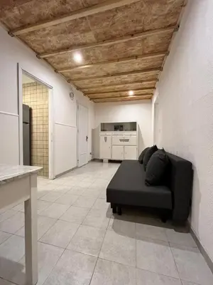 a living room with a black couch and a kitchen at Harin House Casa vacanze in Palermo