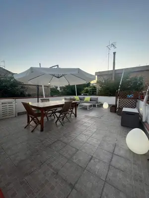 a patio with a table and chairs and an umbrella at Harin House Casa vacanze in Palermo
