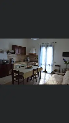 a living room with a table and a kitchen at Vacanze Da Laura in San Vito lo Capo