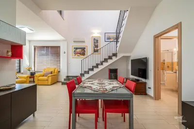 a kitchen and dining room with a table and red chairs at Villa DellOmbra in Alcamo