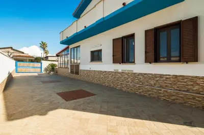 a house with a retaining wall and a patio at Villa DellOmbra in Alcamo