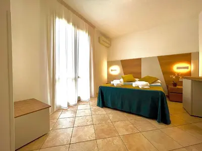 a room with a bed and a large window at Hotel Sikania in San Vito lo Capo