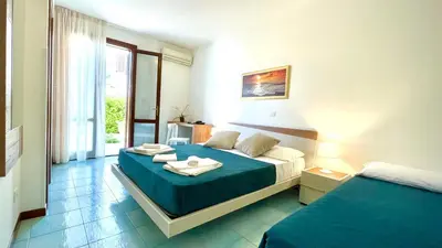 a hotel room with two beds and a window at Hotel Sikania in San Vito lo Capo