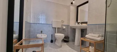 a bathroom with a toilet and a sink and a mirror at Palermo Amari in Palermo