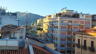 a group of buildings with mountains in the background at Palermo Amari in Palermo